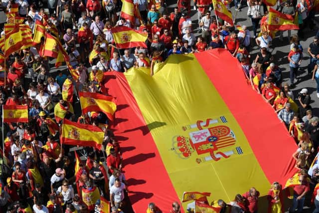 Protesters hold a giant Spanish flag during a demonstration called by "Societat Civil Catalana" (Catalan Civil Society) to support the unity of Spain on October 8, 2017 in Barcelona.
 Picture: Getty Images