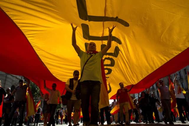Protesters hols a giant Spanish flag during a demonstration called by "Societat Civil Catalana" (Catalan Civil Society) to support the unity of Spain on October 8, 2017 in Barcelona.
Picture: Getty Images