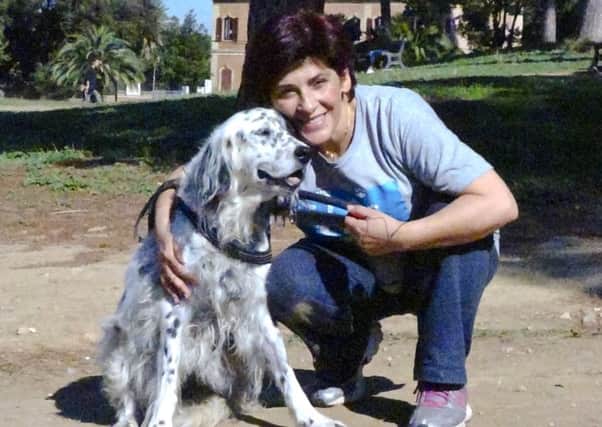 The Italian librarian has won the right from her employer to use family sick leave to care for her ailing pet instead of having to use vacation days, posing with her dog Cucciola in a park in Rome. (Str/ANSA via AP)