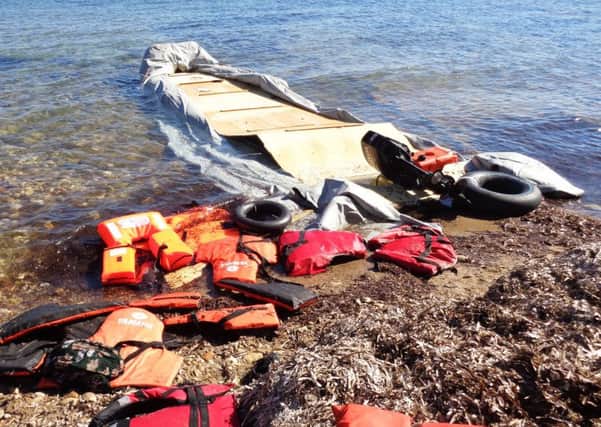 Discarded life-jackets litter the beach at Chios after 64 refugees arrived on this flimsy-looking boat. Photograph: Simona Cheli