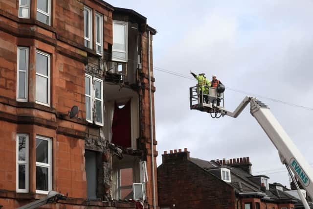 Workmen survey the damage to a block of flats in Crosshill, in the south side of Glasgow, after part of  the front  was brought down in high winds. Picture; PA