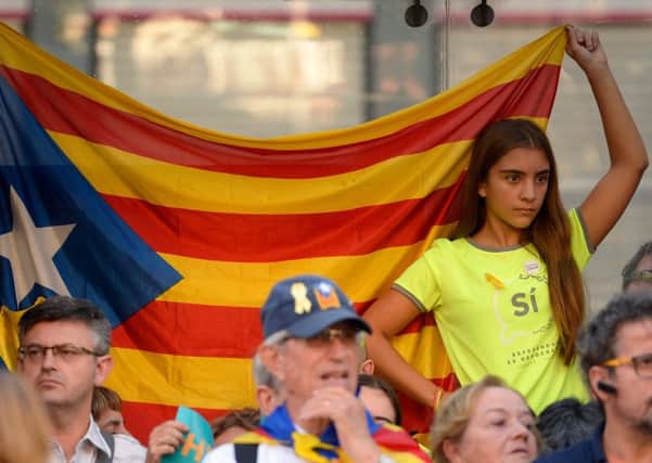 A young woman holds a pro-independence Catalan Estelada flag during a demonstration in Barcelona. Regional elections will take place on Thursday. Picture: AFP/Josep Lago/Getty Images