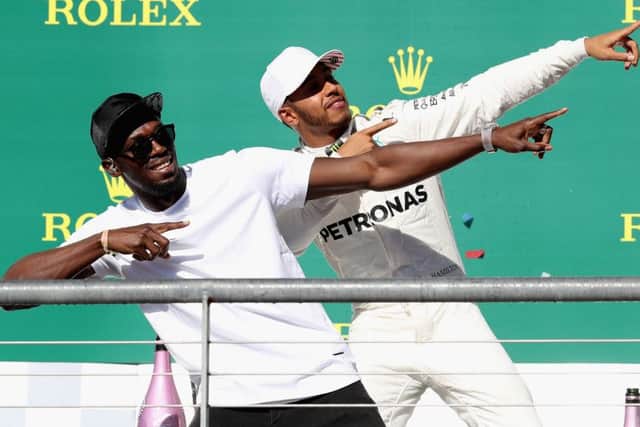 US Grand Prix winner Lewis Hamilton celebrates on the podium with sprinting legend Usain Bolt. Picture: Getty.