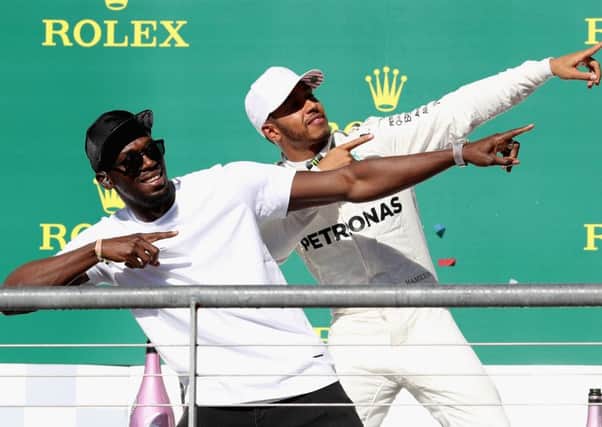 US Grand Prix winner Lewis Hamilton celebrates on the podium with sprinting legend Usain Bolt. Picture: Getty.