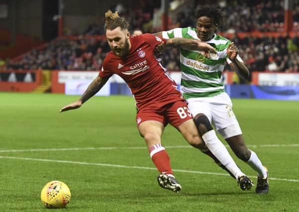 Dedryck Boyata keeps a close eye on Stevie May as Celtic dominated proceedings at Pittodrie. Picture: SNS Group