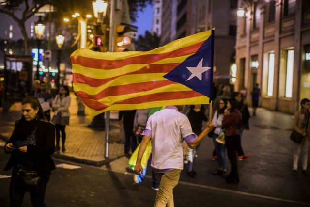 A man walks holding an independence flag in downtown Barcelona. Picture: AP/Santi Palacios