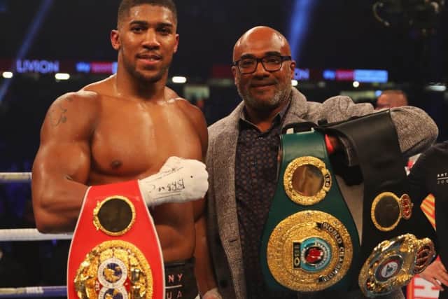 Anthony Joshua displays his belts alongside his father, Robert Joshua, following his defeat of Carlos Takam. Picture: Getty.