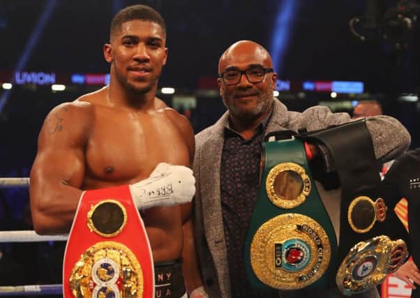 Anthony Joshua displays his belts alongside his father, Robert Joshua, following his defeat of Carlos Takam. Picture: Getty.