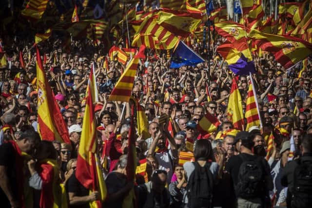 Nationalist activists march with Catalan, Spanish and European Union flags during a mass rally against Catalonia's declaration of independence in Barcelona. Picture: AP Photo/Santi Palacios