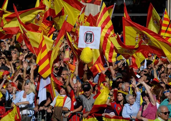 Protesters wave Spanish and Catalan flags at a pro-unity demo in Barcelona following the declaration of independence. Picture: Getty