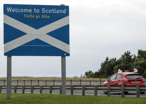 A car adorned with St George's Cross flags passes a welcome sign as it crosses the border into Scotland near Berwick-upon-Tweed in northern England close to the border between England and Scotland on June 26, 2016. Scotland's First Minister Nicola Sturgeon campaigned strongly for Britain to remain in the EU, but the vote to leave has given the Scottish National Party leader a fresh shot at securing independence. Sturgeon predicted more than a year ago that a British vote to leave the alliance would give pro-European Scots cause to hold a second referendum on breaking with the UK.  / AFP / OLI SCARFF        (Photo credit should read OLI SCARFF/AFP/Getty Images)