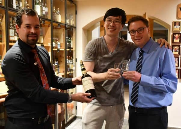Zhang tastes the whisky with the manager of the Waldhaus am See Hotel.