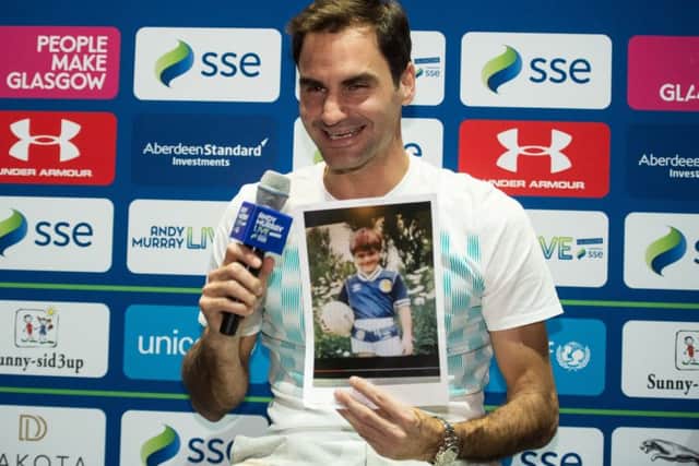 Roger Federer holds a photograph of himself as a young boy wearing a Scotland football strip. Picture: John Devlin