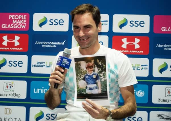 Roger Federer holds a photograph of himself as a young boy wearing a Scotland football strip. Picture: John Devlin