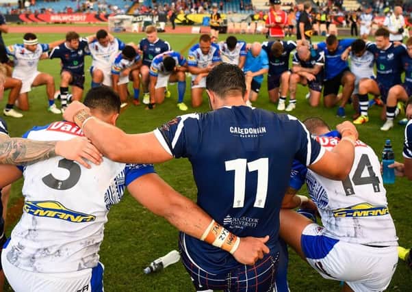 Samoan and Scottish players come together in prayer in Cairns, Australia. Picture:  Ian Hitchcock/Getty Images