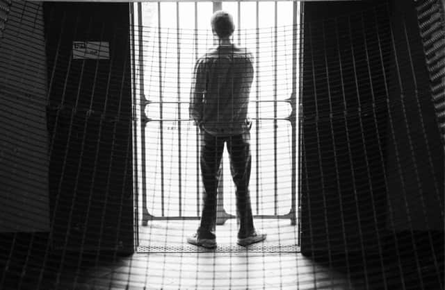 A prisoner looking through the bars of C Hall, in Edinburgh's Saughton prison. Mobile phone use among prisoners has risen sharply in recent years. Picture: Ian Rutherford/TSPL