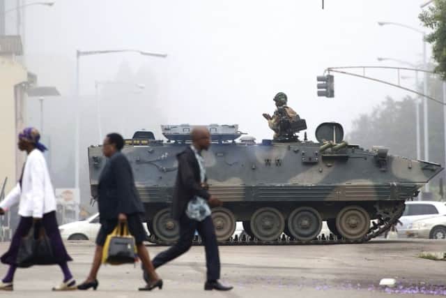 An armed soldier patrols a street in Harare, Zimbabwe  (AP Photo)