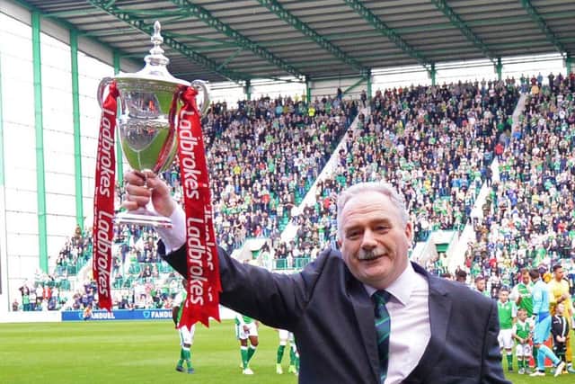 Hibs chairman Rod Petrie holds aloft the Championship trophy. Pic: SNS