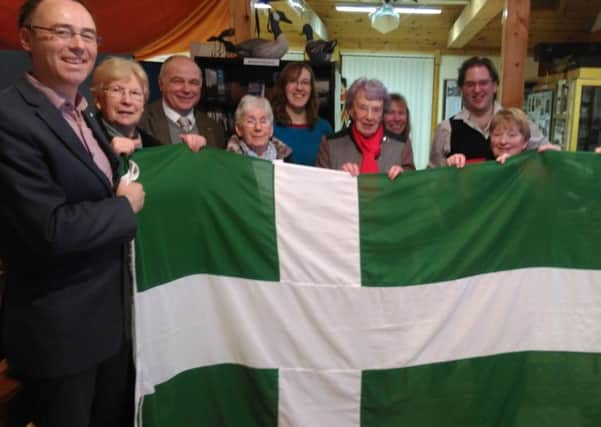 Alasdair Allan MSP (left), with the Barra Flag being held by Barra community members. Photo: Alasdair Allan/PA Wire