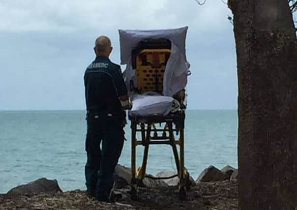 Queensland Ambulance Service paramedic Graeme Cooper looks out at the ocean with the dying patient. Picture: Queensland Ambulance Service