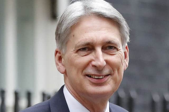 Britain's Chancellor of the Exchequer Philip Hammond poses for the media as he holds up the traditional red dispatch box, outside his official residence 11 Downing Street before delivering his annual budget speech to Parliament in London, Wednesday, Nov. 22, 2017. While Hammond is promising to tackle a bleak economic outlook "head on," a slowing economy and stubborn deficit mean there is little money available to increase spending in the face of demands from teachers, firefighters, the National Health Service and the military. (AP Photo/Frank Augstein)