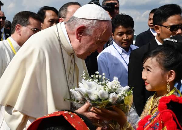 Pope Francis receives flowers upon his arrival at Yangon International Airport. Picture: VINCENZO PINTO/AFP/Getty Images