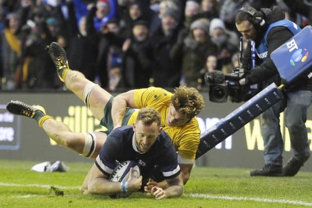 Australia's Michael Hooper can't stop Byron McGuigan touching down one of Scotland's eight tries. Picture: Neil Hanna