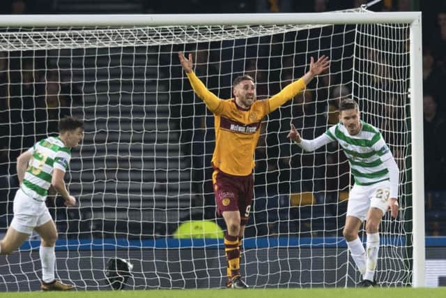 Louis Moult appears for a penalty after claiming to be tripped by Kieran Tierney, left. Picture: SNS