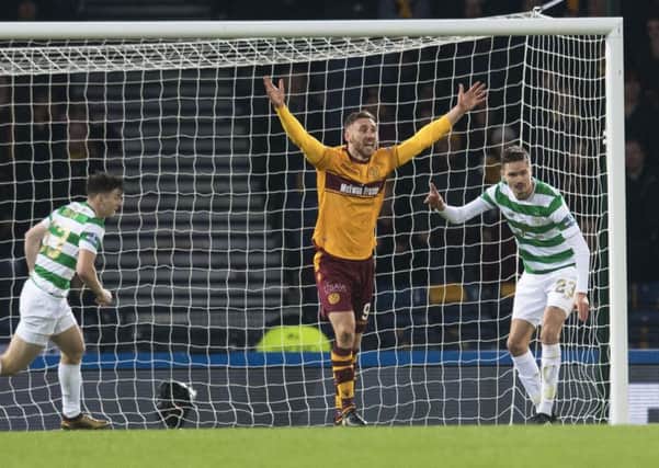 Louis Moult appears for a penalty after claiming to be tripped by Kieran Tierney, left. Picture: SNS