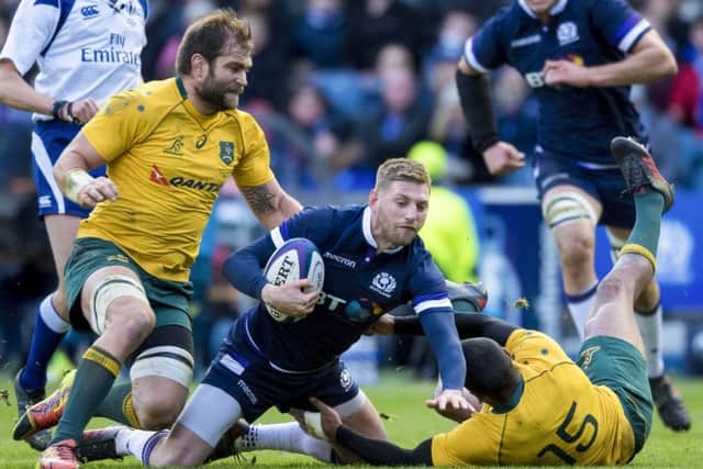 Finn Russell (centre) is tackled by Kurtley Beale during Scotland's 54-23 win. Picture: SNS Group