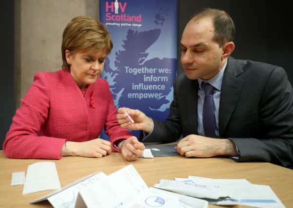 First Minister Nicola Sturgeon is given an HIV test by George Valiotis, chief executive of HIV Scotland ahead of World AIDs Day. Picture: Jane Barlow/PA Wire