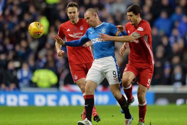 Aberdeen's Anthony O'Conner and Andy Considine challenge Kenny Miller. Picture: PA
