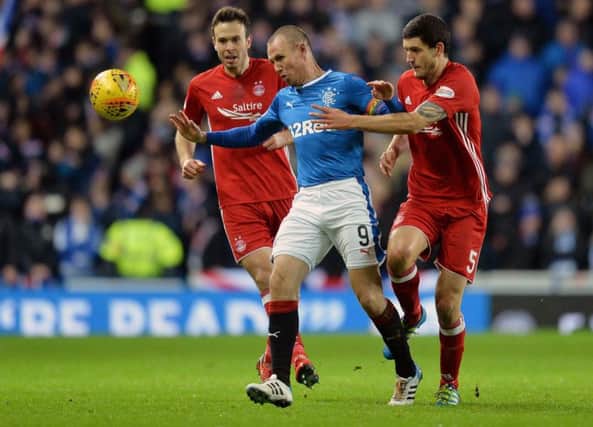 Aberdeen's Anthony O'Conner and Andy Considine challenge Kenny Miller. Picture: PA