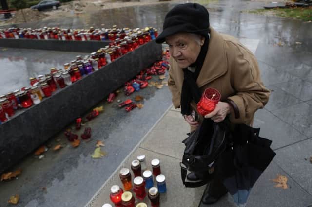A Bosnian Croat woman lights a candle in memory of Slobodan Praljak, in the southern Bosnian town of Mostar 140 kms south of Sarajevo. Picture: AP Photo/Amel Emric