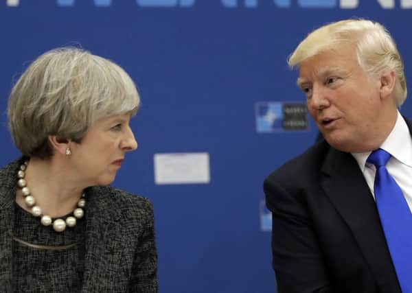 Donald Trump, right, speaks to Prime Minister Theresa May during a NATO summit of heads of state in Brussels. Picture: AP/Matt Dunham