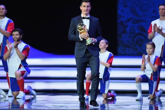 Ex-Germany striker Miroslav Klose walks onstage with the trophy during the Final Draw. Picture: Getty Images