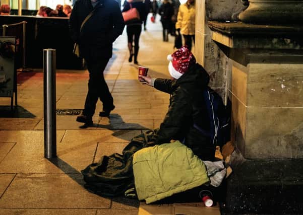 A man begs passersby for money in Royal Exchange Square, Glasgow. Picture: John Devlin