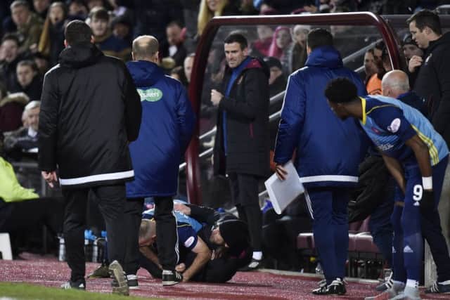 Hearts assistant coach Austin MacPhee and Hamilton's Darian Mackinnon fall to the ground. Picture: SNS.