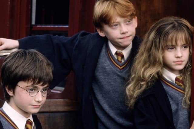 Harry, Ron and Hermione encounter Fluffy: They were lookin straicht intae the een o a monstrous dug, a dug that filled the haill space atween ceilin and flair. It had three heids. Picture: Warner Bros
