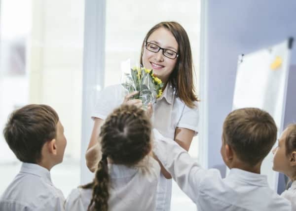 Schoolchildren give flowers to their teacher. (Picture: Getty)