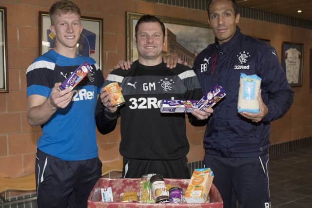 Bruno Alves, right, joins Rangers team-mate Ross McCrorie, left, and interim manager Graeme Murty to help promote the Rangers Charity Foundation's food bank collection before Saturday's game with Ross County. Fans are asked to bring non-perishable food items to a collection point outside the megastore. Picture: Craig Foy/SNS