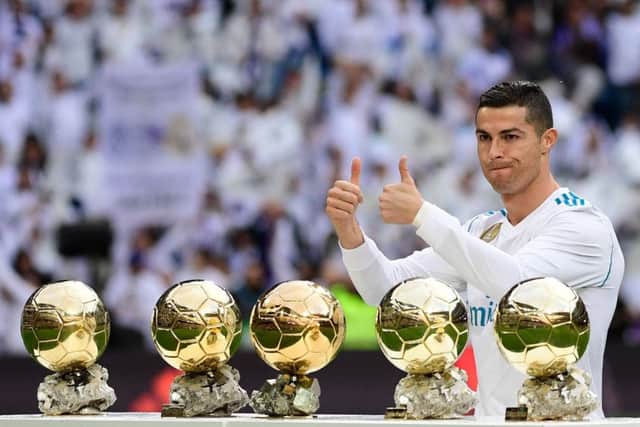 Real Madrid's Portuguese forward Cristiano Ronaldo poses with his five Ballon d'Or trophies. He's now got the same haul as Lionel Messi. Picture: AFP/Getty Images