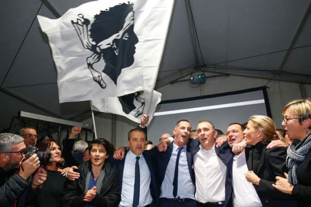 Candidates for the Pe a Corsica nationalist party Jean Guy Talamoni (4L) and Gilles Simeoni (5L) celebrate with party members and supporters after the annoucement of the results in the territorial elections in Bastia on the French Mediterranean Island of Corsica. Picture: Getty Images