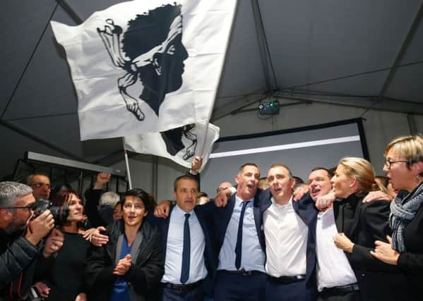 Candidates for the Pe a Corsica nationalist party Jean Guy Talamoni (4L) and Gilles Simeoni (5L) celebrate with party members and supporters after the annoucement of the results in the territorial elections in Bastia on the French Mediterranean Island of Corsica. Picture: Getty Images