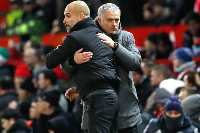 Pep Guardiola and Jose Mourinho share an embrace - sort of - at the end of Manchester City's 2-1 win over Manchester United at Old Trafford. Picture: Martin Rickett/PA