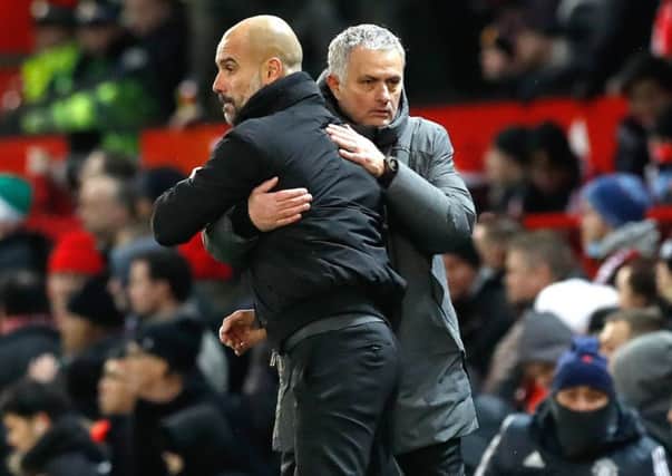 Pep Guardiola and Jose Mourinho share an embrace - sort of - at the end of Manchester City's 2-1 win over Manchester United at Old Trafford. Picture: Martin Rickett/PA