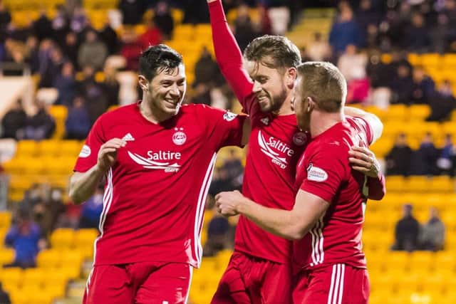 Scott McKenna, left, and other goalscorer Adam Rooney, right, celebrate with Kari Arnason. Picture: SNS