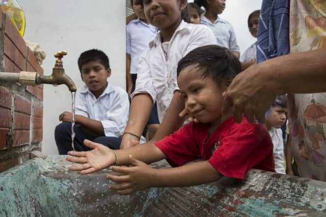 Children enjoy clean water to wash next to the new toilet block at Altamarani. Photograph: Christian Aid/Elaine Duigenan