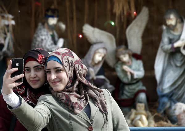 Muslim women take a selfie in front of the Christian manger in front of the Church of the Nativity in Bethlehem. Picture: AFP/Getty