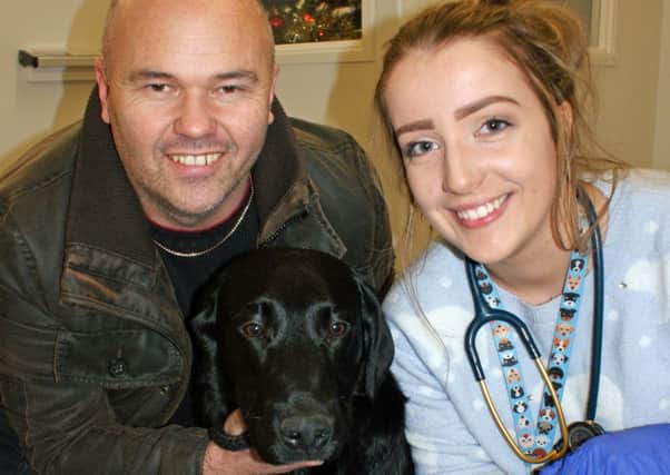 Vet Zoe Caldwell with Kai the labrador and owner Iain Dow. Picture: PA
